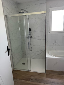 Photo de galerie - Réhabilitation d’une douche, en changeant le bac à douche, la paroi de douche et en posant des panneaux blancs, marbre au mur