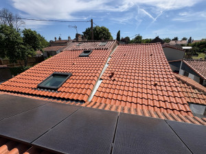 Photo de galerie - Rénovation complète d'une toiture complexe en tuiles romanes avec intégration de fenêtres de toit Velux et d'un raccord en noue sur mesure.