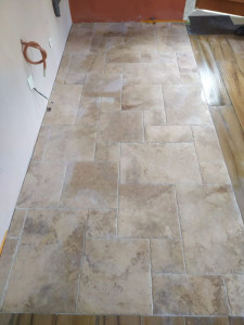 Photo de galerie - Pose d'un carrelage en pierre dans une cuisine sur un plancher en bois, avec natte de désolidarisation 