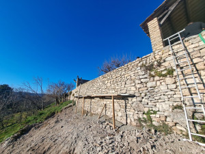 Photo de galerie - Reconstruction du mur en pierre devant le mur en beton.