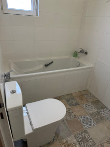 Photo de galerie - Salle de bain réalisée clé en main : installation de la baignoire, pose de carrelage, installation des WC, raccordement d’un sèche-serviettes électrique.