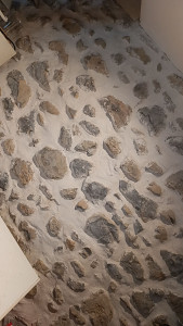 Photo de galerie - Réalisation de rénovation de mur en pierre sur une façade habitation intérieure.