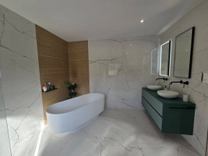 Photo de galerie - Rénovation complète d'une salle de bain, avec installation de baignoire, meuble vasque, plomberie, électricité, revêtements muraux et finitions soignées. Réalisation sur mesure, de A à Z.