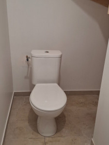 Photo de galerie - Installation d'un WC – raccordement sanitaire et pose soignée.