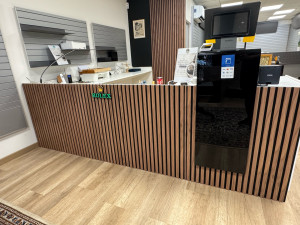 Photo de galerie - Mise en place de tasseaux en bois pour habiller un comptoir d’une boutique alliance sixième, résultat chic et très élégant