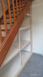 Photo de galerie - Aménagement de l'espace sous l'escalier en zone de rangement.