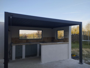 Photo de galerie - Création d une cuisine d' été , toiture pergola bioclimatique,plan de travail béton avec pose de travertin