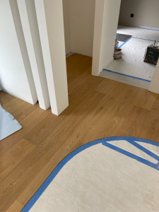 Photo de galerie - Pose de parquet massif affleurant au carrelage (protégé) 
et découpe en contour de poteaux béton.