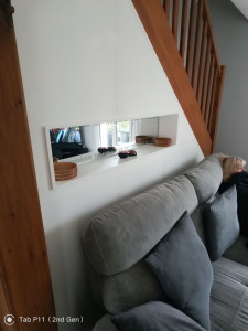 Photo de galerie - Agencement sous escalier avec placard et miroir dans une niche.