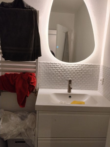 Photo de galerie - Pose d'un miroir led et de la mosaïque au mur 