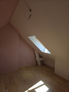 Photo de galerie - Peinture mur rose et plafond mansardé en blanc ainsi que poutre en bois . 