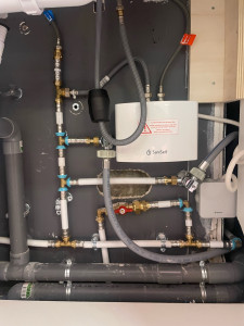 Photo de galerie - Installation d’un chauffe-eau instantané SaniSelf avec raccordement en multicouche, vanne d’arrêt, évacuation en PVC et protection électrique Würth. Vérification de l’étanchéité et des fixations pour une installation fiable et conforme.