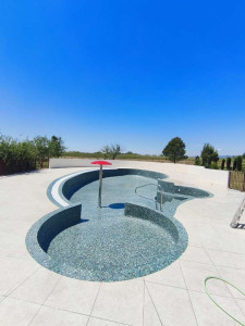 Photo de galerie - Réalisation d'une piscine en pâte de verre et terrasse en carrelage.