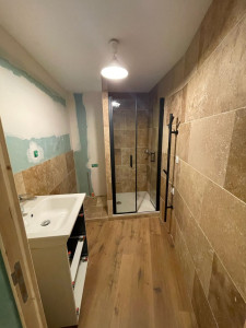 Photo de galerie - Chantier Toulon rénovation appartement
salle de bain remplacement baignoire par une douche, agencement emplacement machine a laver, sol PVC, placo hydrofuge, travertin en habillage mur 