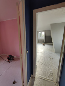 Photo de galerie - Peinture sur l'ensemble de la maison, avec plusieurs couleurs, bleu dans le couloir, rose dans la chambre du bébé et plusieurs nuances de gris dans la chambre des parents