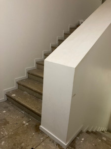 Photo de galerie - Pose de plinthe le long d’un escalier en pierre de taille.