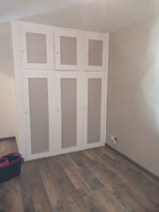 Photo de galerie - Création d'un placard sur mesure intégré au mur et pose au sol d'un parquet flottant et plinthes. 