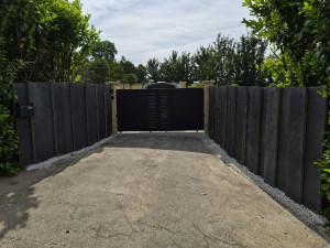 Photo de galerie - Aménagement extérieur avec des plaques de schiste en ardoise naturelle, associées à un portail noir pour un rendu moderne, élégant et durable.