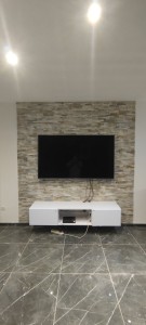 Photo de galerie - Pose de 6m2 de plaquette de parement en pierre naturelle+ modification de fixation du support tv+montage mural du meuble bas chez une cliente 