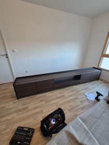 Photo de galerie - Montage et installation d’un meuble TV moderne composé de plusieurs éléments. Assemblage soigné, alignement et ajustement des portes et tiroirs pour un résultat propre, stable et esthétique.