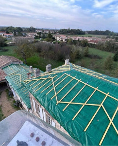 Photo de galerie - Dépose de l’ancienne couverture, mise en place d’une bâche de protection pour sécuriser la maison pendant les travaux, puis pose des liteaux en préparation de la nouvelle couverture. 