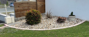 Photo de galerie - Création et aménagement d’un massif : pose de pavés, mise en place de gravier décoratif et plantation.