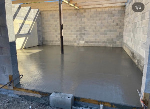 Photo de galerie - Dalle béton neuve coulée et lissée, prête pour la suite du chantier.