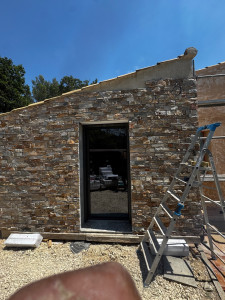 Photo de galerie - Réalisation d’un mur en carrelage effet pierre, avec une pose soignée et des finitions propres. Idéal pour donner un style moderne et chaleureux à votre intérieur ou extérieur.