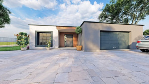 Photo de galerie - Cette villa de 100 m² de plain-pied dispose d’un séjour lumineux avec cuisine ouverte, donnant sur une grande terrasse, une suite parentale, deux chambres, une salle de bain, et un garage intégré. Un style épuré, fonctionnel et ouvert sur l’extérieur.