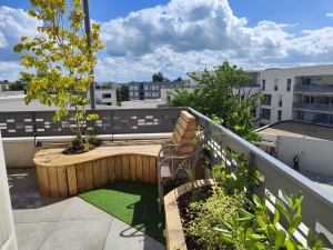 Photo de galerie - Réalisation d'un amménagement complet en bois d'un balcon avec terrasse, jardinières et banquette réalisé sur place et sur mesure