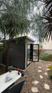 Photo de galerie - Réalisation complète d’un abri de jardin contemporain avec structure aluminium et panneaux design.