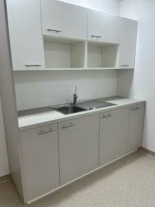 Photo de galerie - Installation complète d'une kitchenette : pose des meubles, découpe du plan de travail, encastrement de l'évier et raccordements de plomberie.