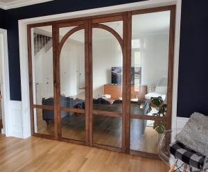 Photo de galerie - Fabrication et pose d’une verrière avec deux portes centrales en noyer massif teint. 