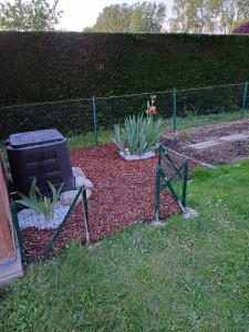 Photo de galerie - Création de potager avec grillage et parterre fleurie pour un emplacement de composteur.