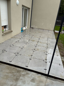 Photo de galerie - Pose d’une terrasse de 21 m² en carrelage 60 × 60. Préparation du support, respect des pentes pour l’évacuation des eaux, pose soignée avec système de nivellement et finitions de qualité.