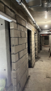 Photo de galerie - Travaux de maçonnerie en sous-sol d’immeuble : réalisation de murs de séparation en agglos béton, avec création d’ouvertures pour les portes. Montage et mise en œuvre soignés.