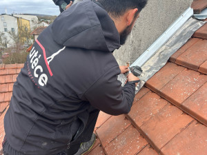 Photo de galerie - Pose de bande porte solin en zinc et plomb sur cheminée.