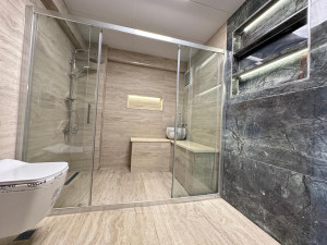 Photo de galerie - Rénovation de salle de bain avec pose de carrelage grand format effet marbre blanc, revêtement mural et sol, réalisation de finitions soignées pour un rendu moderne, élégant et haut de gamme.