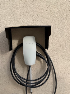 Photo de galerie - Installation d’une borne de recharge Tesla à domicile avec création d’un tableau électrique dédié et passage des câbles. Travail soigné et finition propre.