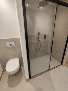 Photo de galerie - Passe d'un WC suspendu gébérit et une douche avec paroi coulissante bac à douche design extra-plat recoupable et robinetterie encastré