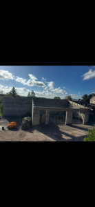 Photo de galerie - Construction en cours Les murs de la maison sont montés en blocs de béton. Les ouvertures pour les portes et fenêtres sont visibles. C’est l’étape de base avant de finir la maison.