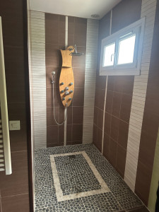 Photo de galerie - Rénovation de salle de bain avec pose de carrelage grand format effet marbre blanc, revêtement mural et sol, réalisation de finitions soignées pour un rendu moderne, élégant et haut de gamme.