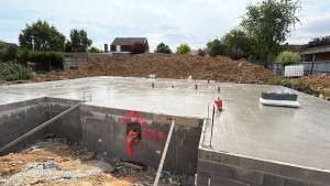 Photo de galerie - Nous avons réalisé la dalle en béton qui sert de base au bâtiment. Cette étape cruciale garantit la solidité et la planéité du sol de votre future habitation. Parallèlement, nous avons monté les murs en parpaings qui délimitent l'allée.