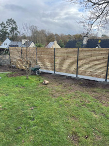 Photo de galerie - Réalisation d’une clôture en bois avec plaque de soubassement béton