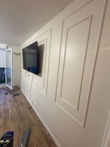Photo de galerie -  Un salon transformé avec une décoration élégante en blanc et des baguettes décoratives pour une finition moderne et raffinée. Chaque détail compte pour sublimer votre intérieur ! 