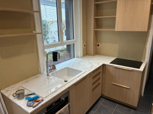 Photo de galerie - Montage et ajustement des meubles de cuisine, pose du plan de travail et intégration de l’évier et de la plaque.  Finitions réalisées après pose.
