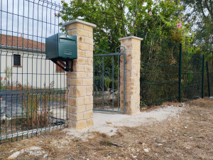 Photo de galerie - Réalisation d'une clôture en grillage rigide, Montage de pilier béton et fondations pour portillon. Pose d'un portillon et enduit déco-pierre