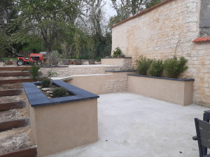 Photo de galerie - Réalisation d'une terrasse, de murets pour jardinière, pose de chapeau et ravalement  avec fausse pierres 