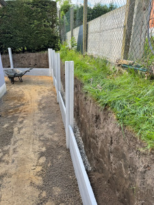 Photo de galerie - Un chantier de terrassement avec mur en plaques béton de soutènement 