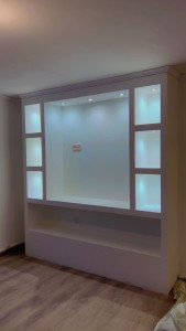 Photo de galerie - Création d'un meuble TV sur mesure en placo avec niches décoratives et éclairage LED intégré.